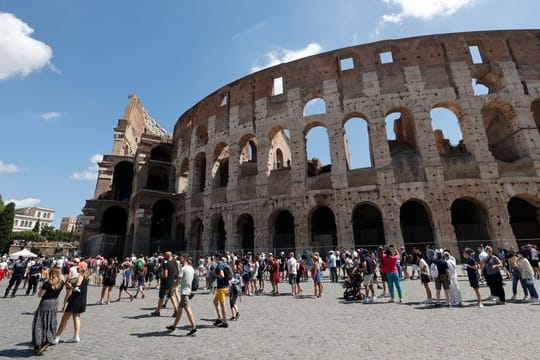 Touristen warten in einer Schlange, um das Kolosseum zu betreten.