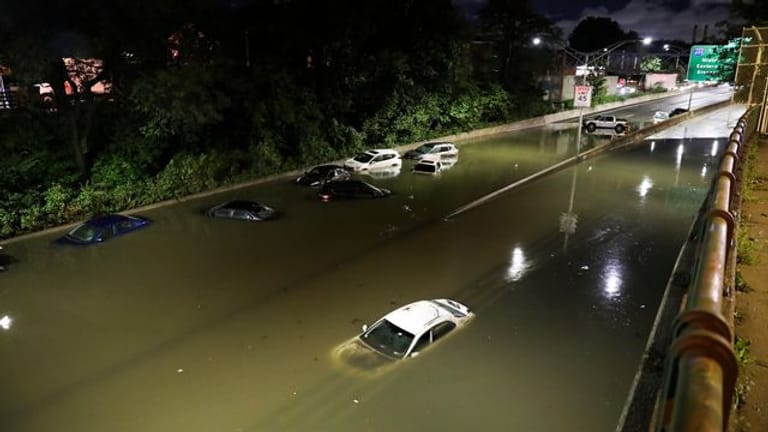 Fahrzeuge stehen im Hochwasser auf einer Straße New Yorks.