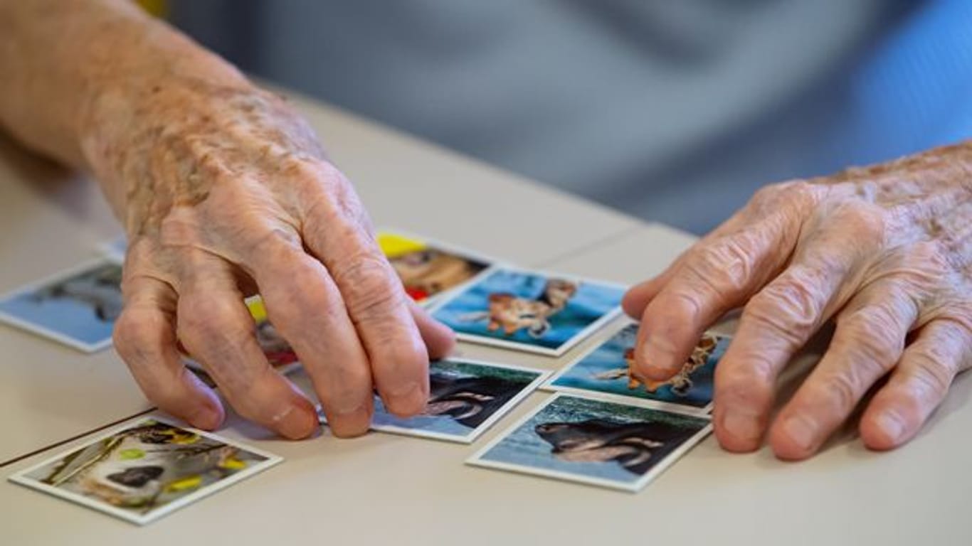 Erinnerung schulen: Eine Bewohnerin einer Pflegestation spielt "Memory".