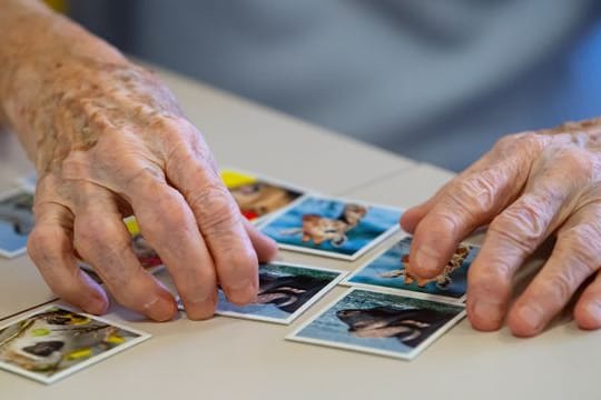 Erinnerung schulen: Eine Bewohnerin einer Pflegestation spielt "Memory".