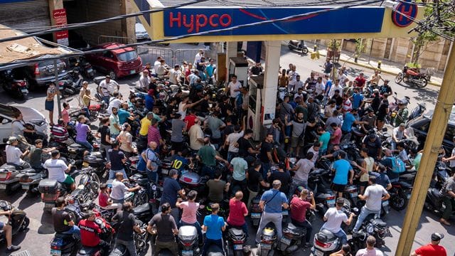 Motorrad- und Rollerfahrer warten an einer Tankstelle. Motorrad- und Rollerfahrer warten an einer Tankstelle.