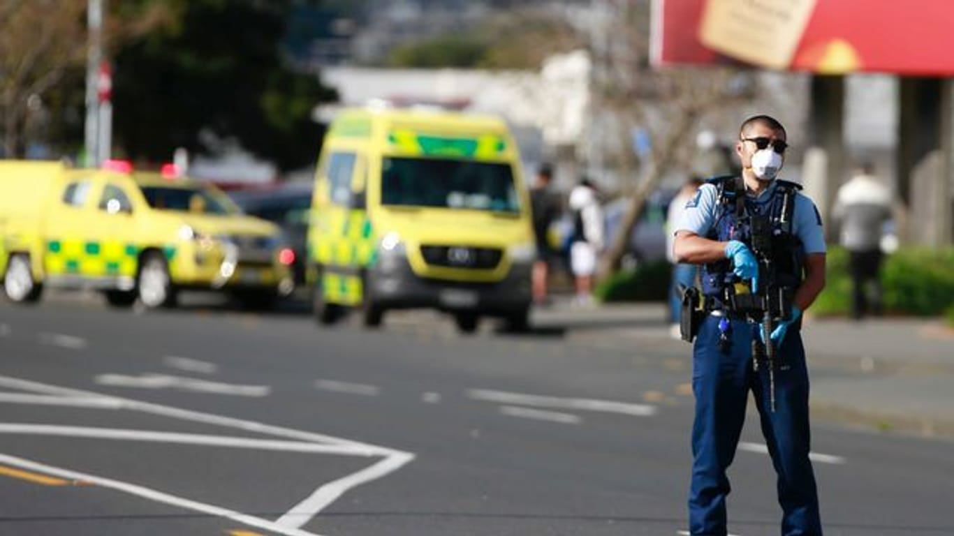Ein Polizist steht vor dem Supermarkt in Auckland, in dem es zu dem Angriff kam.