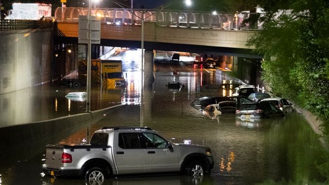 Fahrzeuge in New York stehen im Hochwasser auf einer Straße, die durch die starken Regenfälle, ausgelöst von Hurrikan "Ida", überschwemmt wurden. Fahrzeuge in New York stehen im Hochwasser auf einer Straße, die durch die starken Regenfälle, ausgelöst von Hurrikan "Ida", überschwemmt wurden.