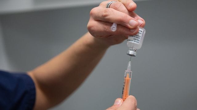 Eine Ärztin füllt im Gesundheitszentrum von Coventry (England) einen Coronavirus-Impfstoff in eine Spritze. Eine Ärztin füllt im Gesundheitszentrum von Coventry (England) einen Coronavirus-Impfstoff in eine Spritze.