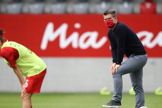 Jens Scheuer, Trainer vom FC Bayern München, beobachtet seine Spielerinnen beim Aufwärmen.