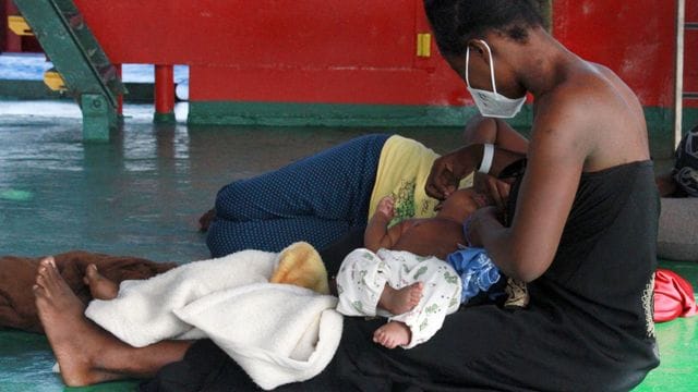 Eine Frau sitzt mit ihren Kindern an Deck des Seenotrettungsschiffs "Sea-Eye 4". Eine Frau sitzt mit ihren Kindern an Deck des Seenotrettungsschiffs "Sea-Eye 4".