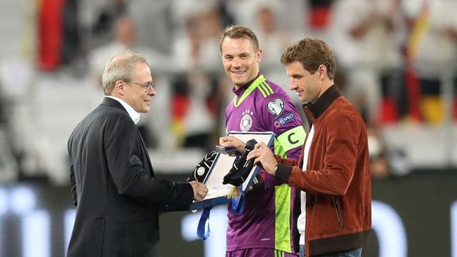 Thomas Müller (r) und Manuel Neuer (M) werden von Peter Peters vor der Partie geehrt. Thomas Müller (r) und Manuel Neuer (M) werden von Peter Peters vor der Partie geehrt.