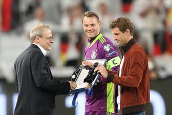 Thomas Müller (r) und Manuel Neuer (M) werden von Peter Peters vor der Partie geehrt.