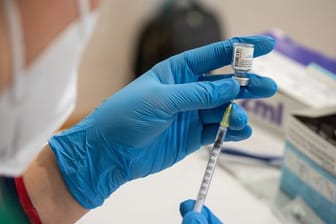 Die Mitarbeiterin eines mobilen Impfteams zieht eine Spritze mit dem Corona-Impfstoff auf.