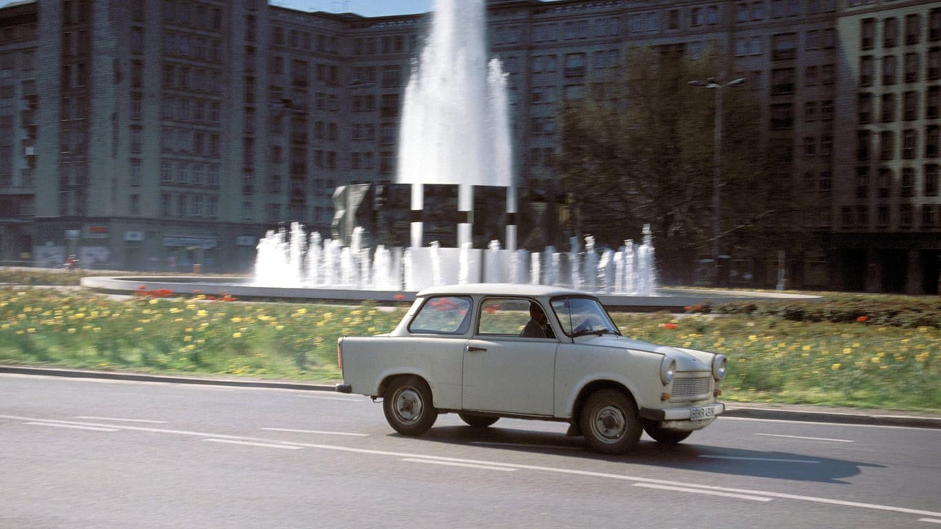 Ein Trabi fährt am Strausberger Platz vorbei: Der Trabant ist ein Kultauto der DDR.