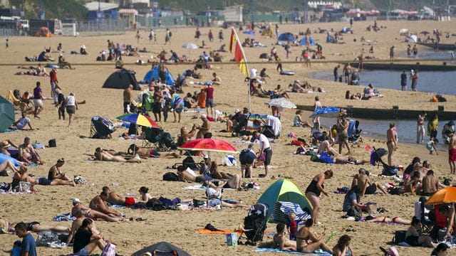 Zahlreiche Menschen genießen das warme Wetter am Strand von Bournemouth. Zahlreiche Menschen genießen das warme Wetter am Strand von Bournemouth.