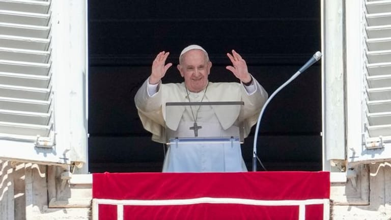 Papst Franziskus grüßt Menschen auf dem Petersplatz.