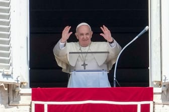 Papst Franziskus grüßt Menschen auf dem Petersplatz.