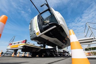 Bei dem Versuchsaufbau auf dem Crashtestgelände kippt ein kleiner mit Insassen besetzter Reisebus per Hydraulik um 90 Grad auf die Seite.