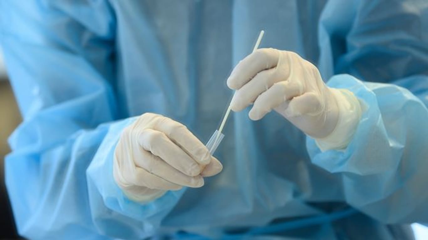 Eine medizinische Mitarbeiterin entnimmt eine Nasenabstrichprobe für einen Coronatest.