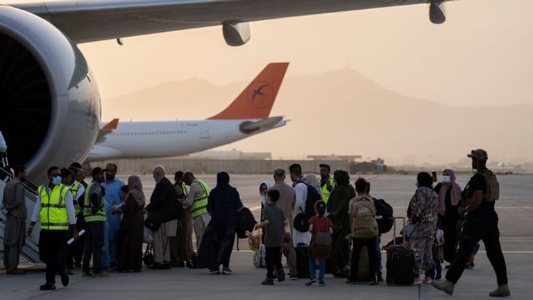 Doppelstaatler, deren Ausreise erlaubt wurde, besteigen in Kabul ein Flugzeug der Fluggesellschaft Qatar Airways.