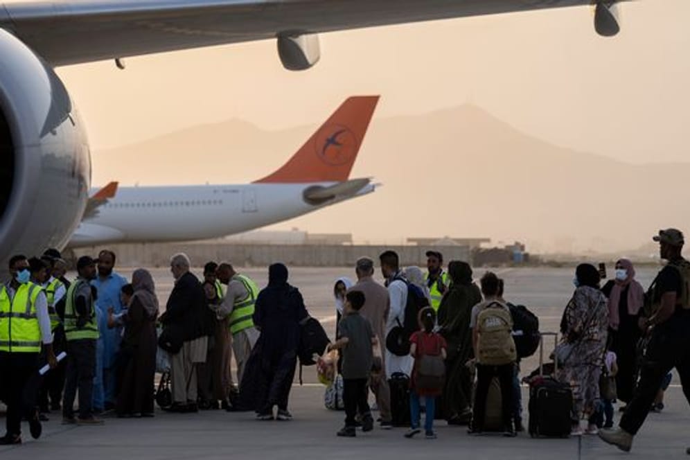 Doppelstaatler, deren Ausreise erlaubt wurde, besteigen in Kabul ein Flugzeug der Fluggesellschaft Qatar Airways.