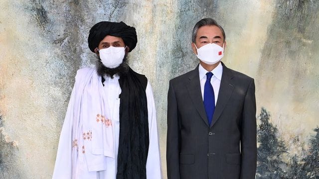 Chinas Außenminister Wang Yi (r) neben einem Führer der Taliban.