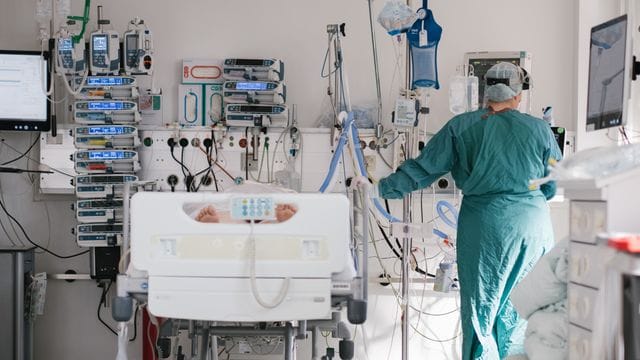 Eine Intensivpflegerin versorgt auf einer Intensivstation einen an Covid-19 erkrankten Patienten (Archivbild).