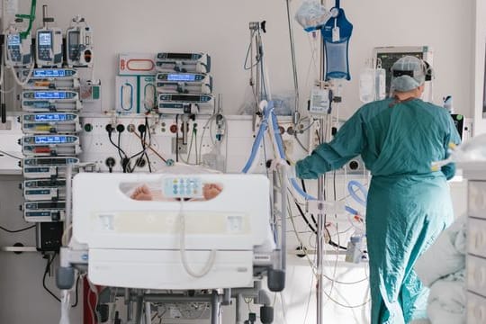 Eine Intensivpflegerin versorgt auf einer Intensivstation einen an Covid-19 erkrankten Patienten (Archivbild).