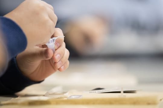 Ein Schüler macht vor der ersten Stunde an einer Schule einen Corona-Schnelltest.