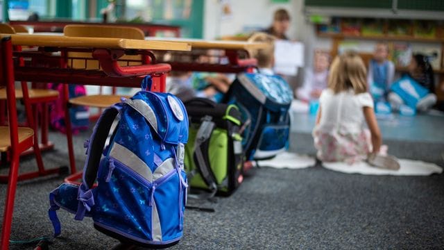 Ranzen hängen und stehen beim Begrüssungsunterricht der neuen Erstklässler im Klassenzimmer.