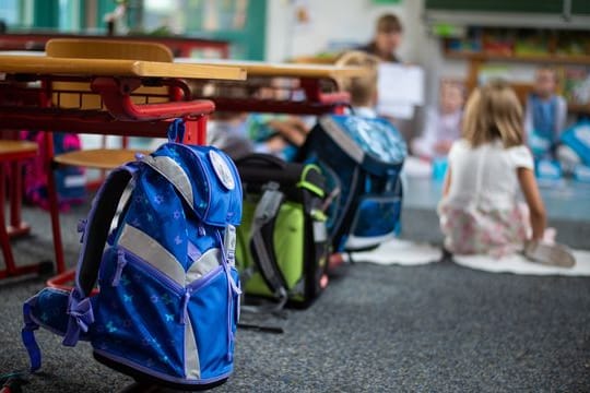 Ranzen hängen und stehen beim Begrüssungsunterricht der neuen Erstklässler im Klassenzimmer.