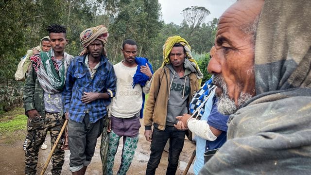 Männer versammeln sich, um mit dem am Arm verletzten Milizionär Kibret Bidere (2. Männer versammeln sich, um mit dem am Arm verletzten Milizionär Kibret Bidere (2.