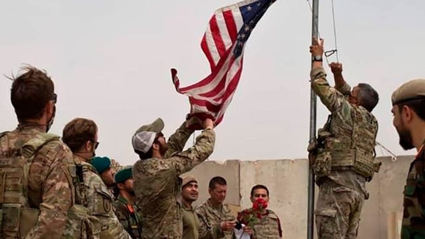 Bei einer Übergabezeremonie von der US-Armee an die afghanische Nationalarmee im Camp Anthonic wird eine US-Flagge vom Mast heruntergelassen.