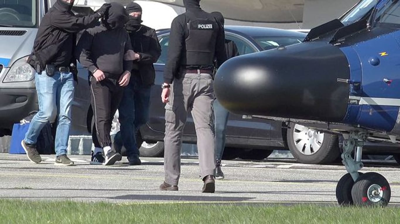 Ein mutmaßliches Mitglied der Terrormiliz IS wird auf dem Flughafen Hamburg zu einem Hubschrauber der Bundespolizei gebracht.