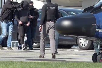 Ein mutmaßliches Mitglied der Terrormiliz IS wird auf dem Flughafen Hamburg zu einem Hubschrauber der Bundespolizei gebracht.