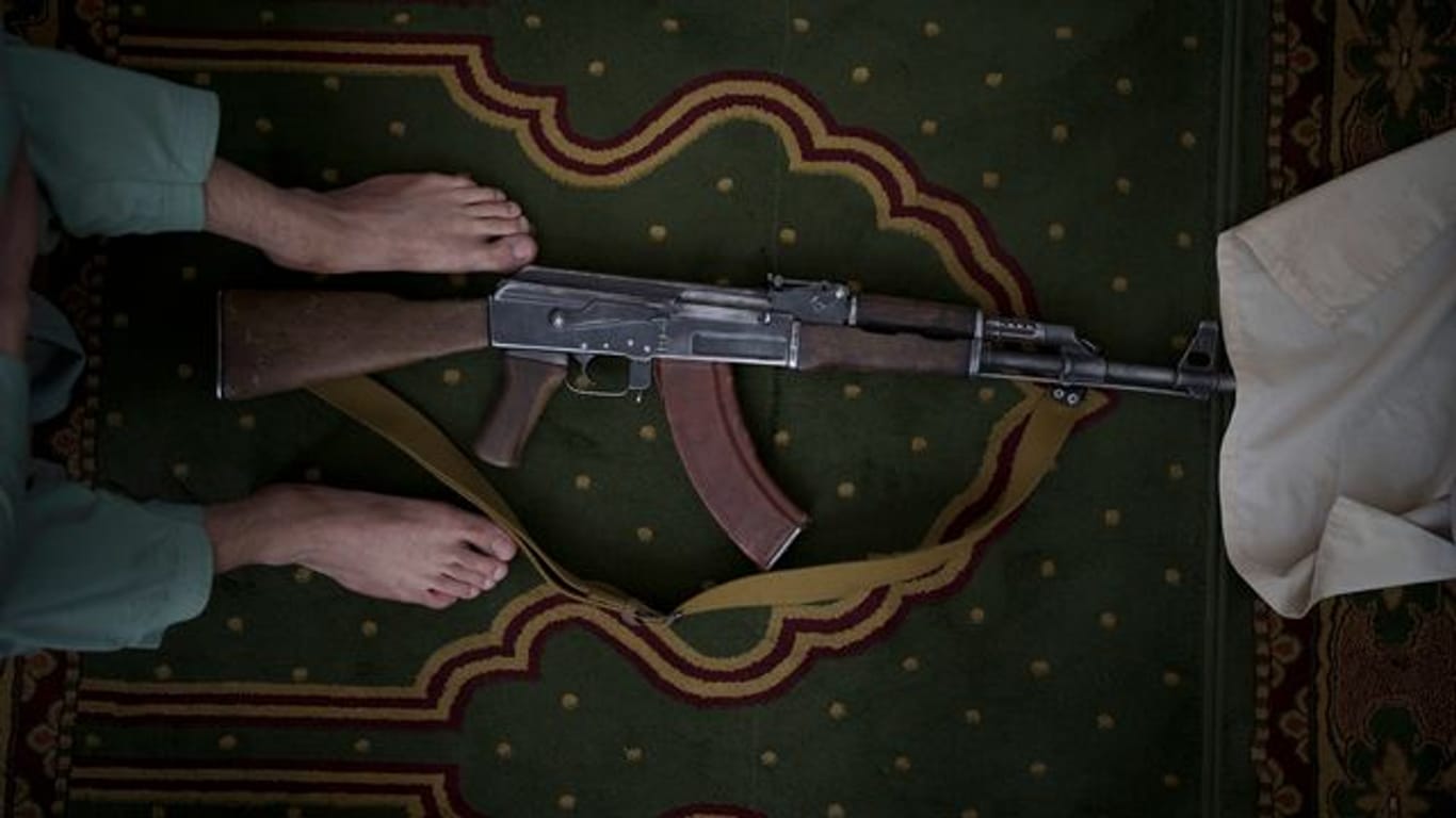 Ein Taliban-Kämpfer nimmt seine Kalaschnikow von Typ AK-47 zum Beten mit in eine Moschee.