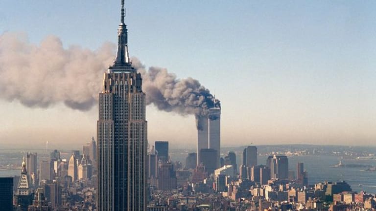 Die Zwillingstürme des World Trade Centers brennen hinter dem Empire State Building.