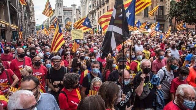 Demonstranten halten die katalanische Unabhängigkeitsfahne in die Höhe.