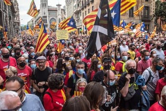 Demonstranten halten die katalanische Unabhängigkeitsfahne in die Höhe.