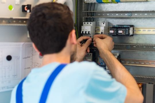Der 19-jährige Mohammad aus Afghanistan arbeitet in einem Leipziger Ausbildungszentrum von Siemens an der Verdrahtung eines Schaltschranks.
