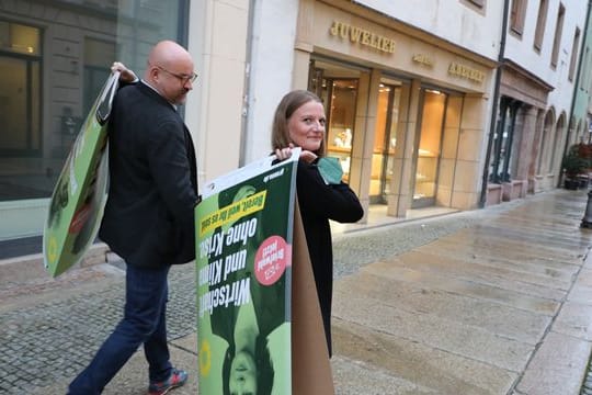 Wolfgang Wetzel, (l) Spitzenkandidat der Grünen und Christin Furtenbacher, Landesvorstandssprecherin der Grünen in Sachsen, laufen mit Wahlplakaten durch die Innenstadt von Zwickau.