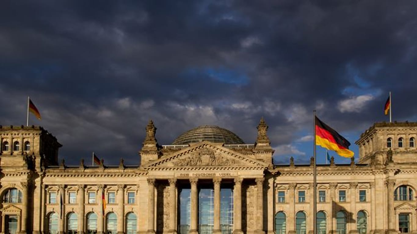 Dunkle Wolken ziehen über das Reichstagsgebäude in Berlin.