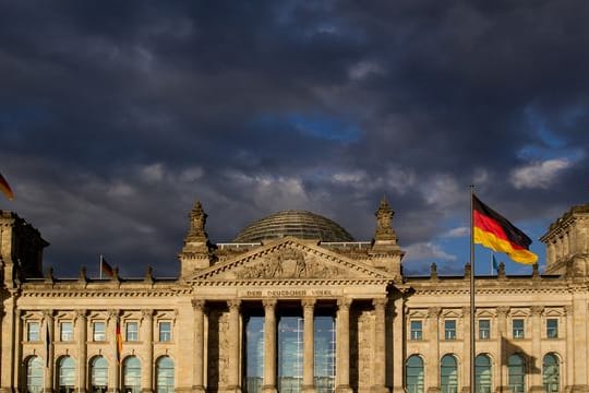 Dunkle Wolken ziehen über das Reichstagsgebäude in Berlin.