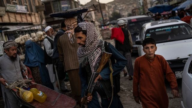 Ein Taliban-Kämpfer patrouilliert auf einem Markt in Kabul (Symbolbild).