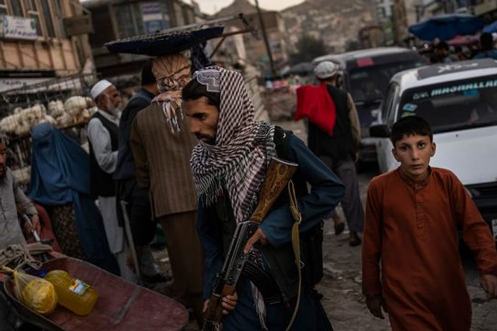 Ein Taliban-Kämpfer patrouilliert auf einem Markt in Kabul (Symbolbild).