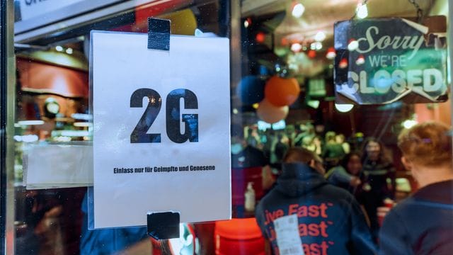 Im Fenster einer Kneipe hängt ein Zettel mit dem Text "2G, Einlass nur für Geimpfte und Genesene". Im Fenster einer Kneipe hängt ein Zettel mit dem Text "2G, Einlass nur für Geimpfte und Genesene".