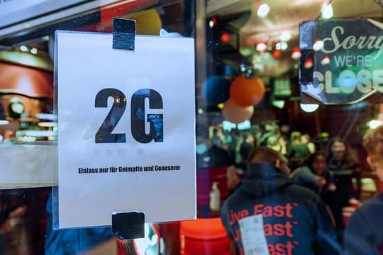 Im Fenster einer Kneipe hängt ein Zettel mit dem Text "2G, Einlass nur für Geimpfte und Genesene".