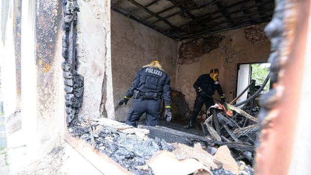 Zwei Brandermittler der Polizei im Einsatz.