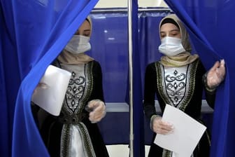 Frauen in tschetschenischer Nationaltracht verlassen eine Wahlkabine in Grosny.