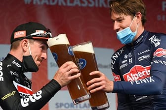 John Degenkolb (l) stößt mit Eschborn-Frankfurt-Sieger Jasper Philipsen an.