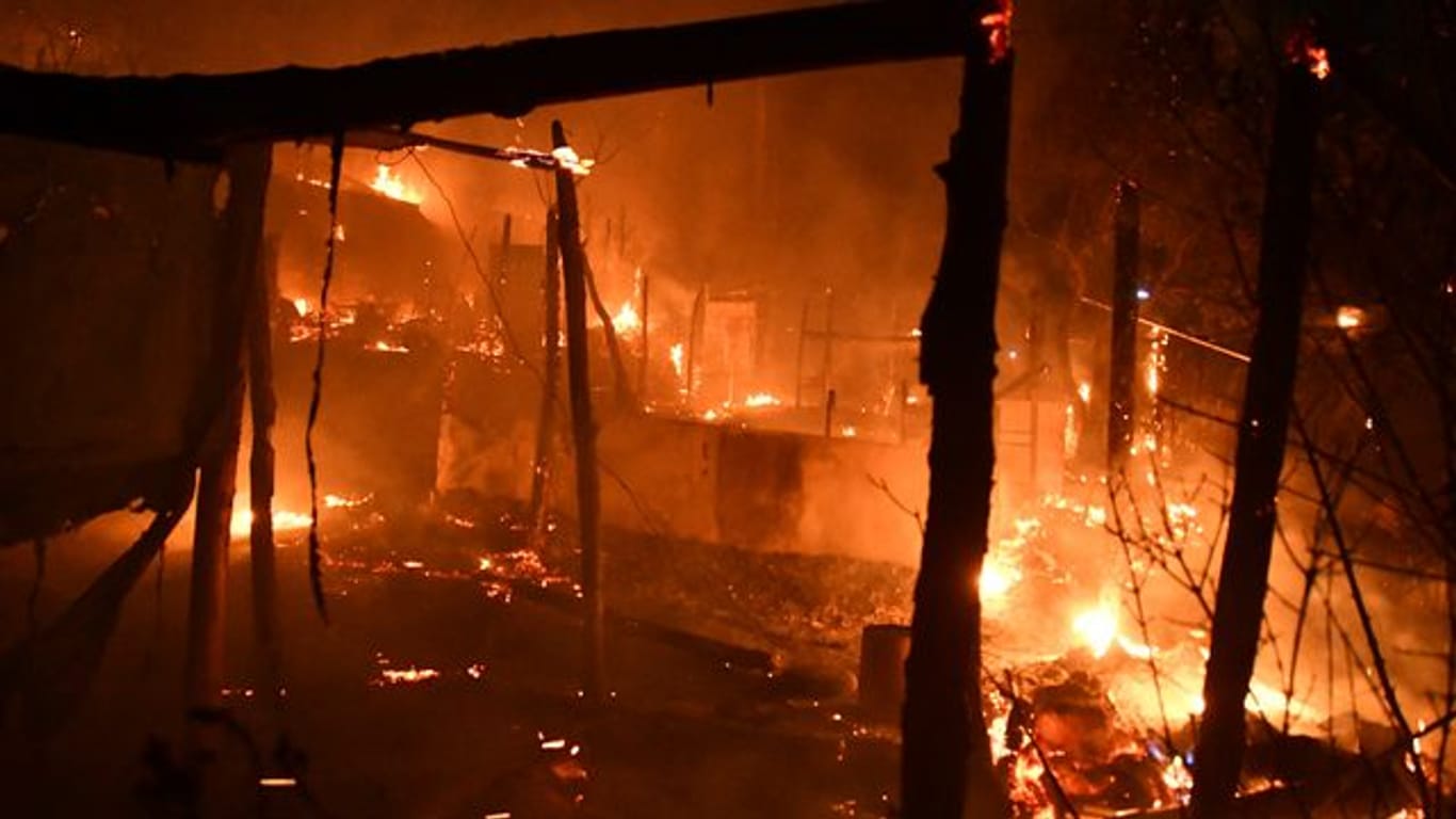 Feuer brennt behelfsmäßige Zelte außerhalb des überfüllten Flüchtlingslagers am Hafen von Vathy auf der ostägäischen Insel Samos ab.