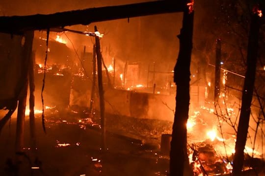 Feuer brennt behelfsmäßige Zelte außerhalb des überfüllten Flüchtlingslagers am Hafen von Vathy auf der ostägäischen Insel Samos ab.