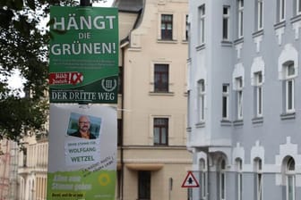 Ein umstrittenes Wahlplakat der Splitterpartei Der Dritte Weg hängt in Zwickau über einem Plakat der Grünen (Archivbild).