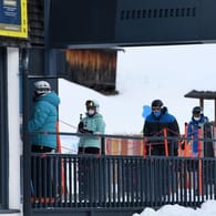 Wintersportler stehen in Tirol mit Mund-Nasen-Schutz an einem Skilift an.